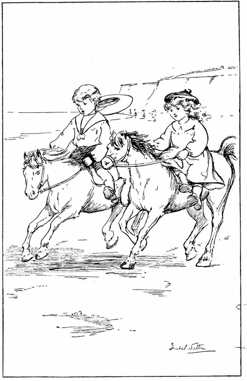 Two children riding ponies on the beach